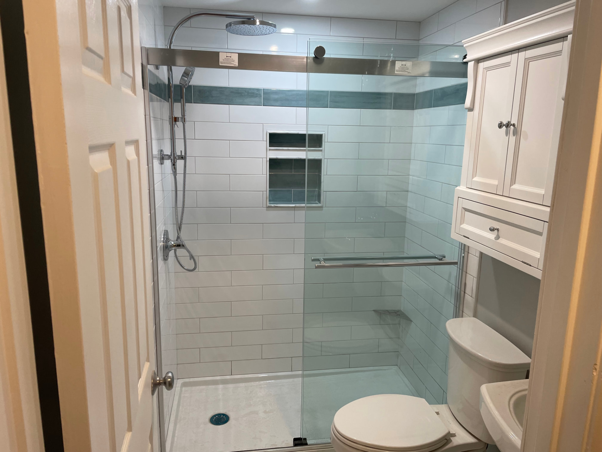 Finished bathroom remodel with walk-in shower, tile, and vanity by Top Shelf Plumbing & Heating